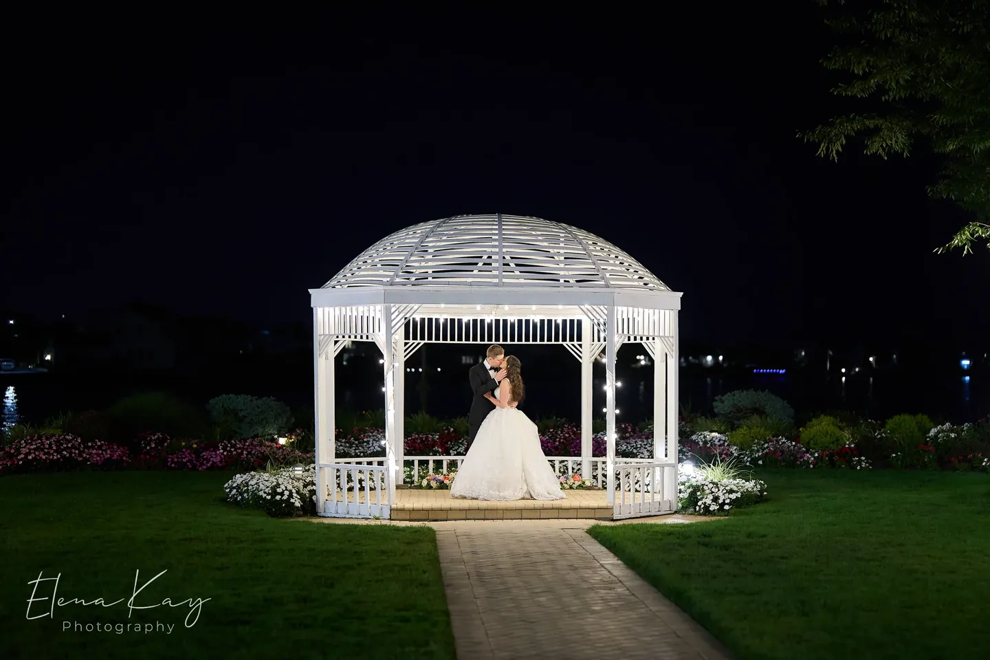 Bride and groom inside the lighted waterfront gazebo at night by Elena Kay Photography